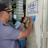 Kapolsek Kota Kuningan saat menempelkan stiker himbauan di pusat keramaian Kota Kuningan.